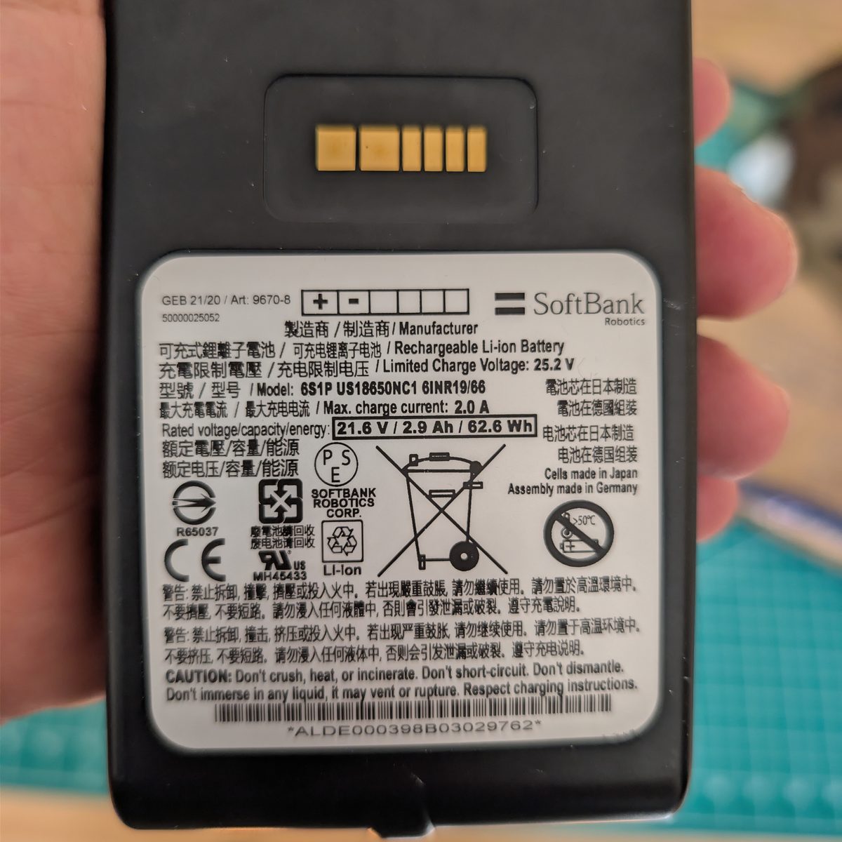 Rear face of a SoftBank Robotics NAO battery pack showing the charge contact block and the specification label