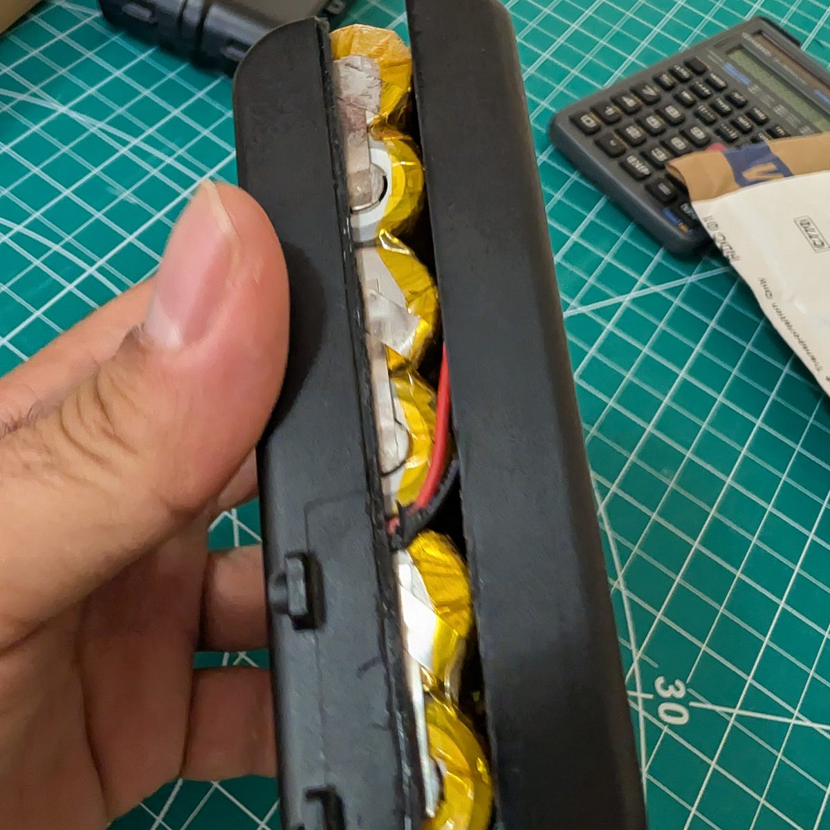 The inside of an opened NAO battery pack showing the original 18650 cells and their wiring
